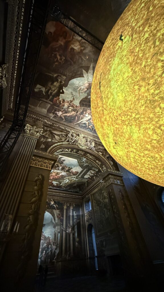 Luke Jerram’s Helios installation glowing beneath the Painted Hall ceiling in Greenwich