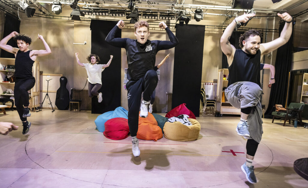 L-R - Onuri Smith (Ensemble), Sophie Hutchinson (Ensemble), Joe Simmons (Greg), Luke Conner Hall (Blaine) and the cast in rehearsals, Credit Pamela Raith Nic Myers as Kathryn Merteuil in a rehearsal shot for Cruel Intentions: The '90s Musical UK and Ireland tour, exuding confidence and charm.
